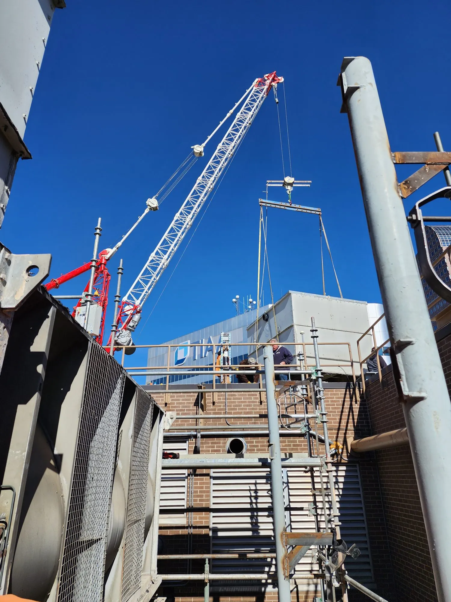 Crane rigging on a downtown rooftop during a cooling plant clear-out