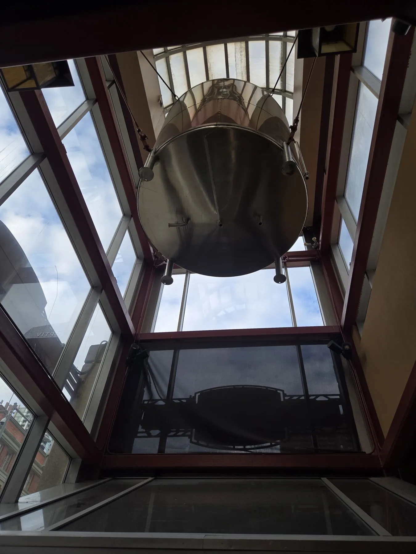 Stainless steel vessel suspended 24 feet up in a glass atrium before removal