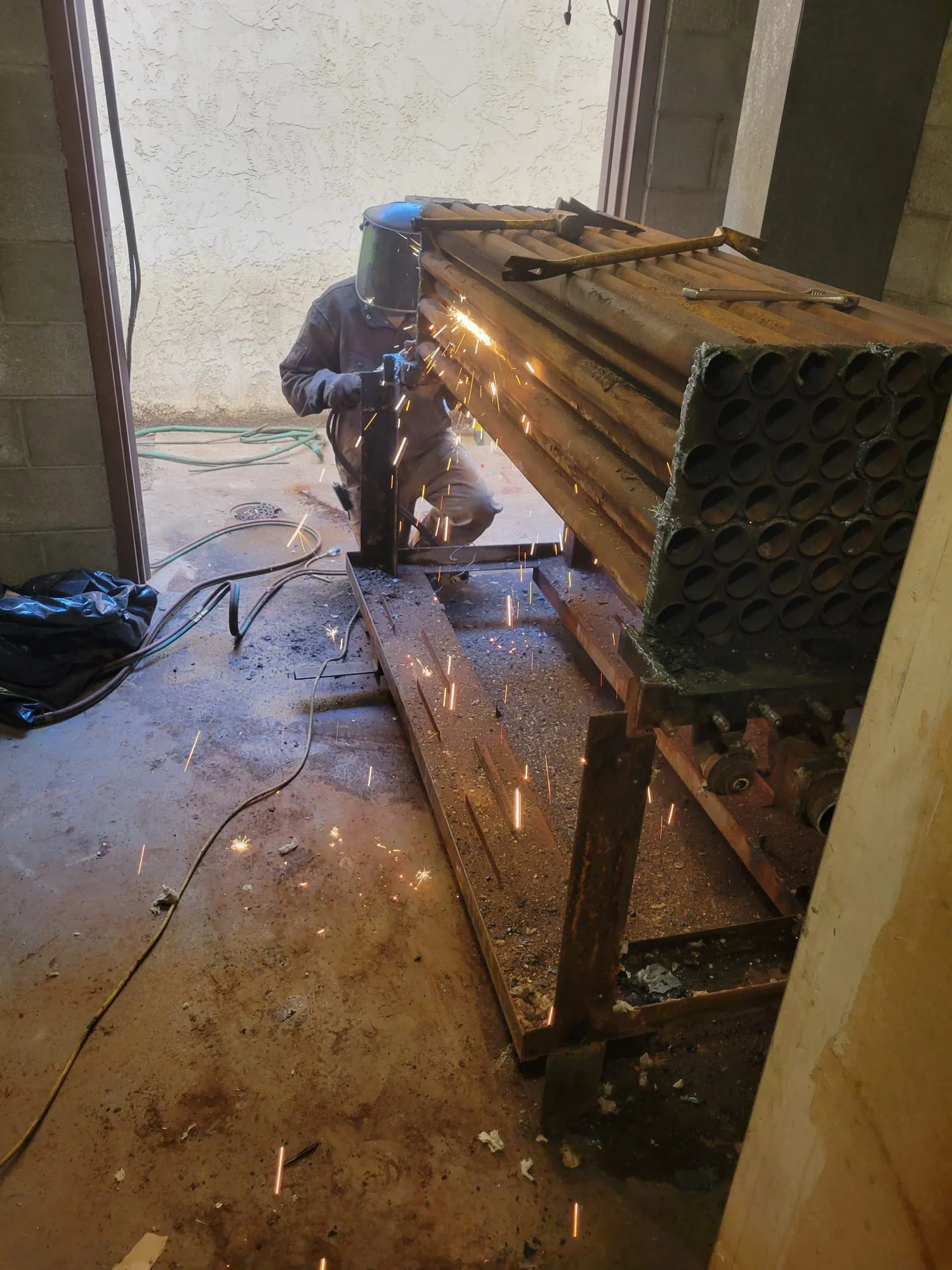 Torch cutting a firetube boiler tube bundle