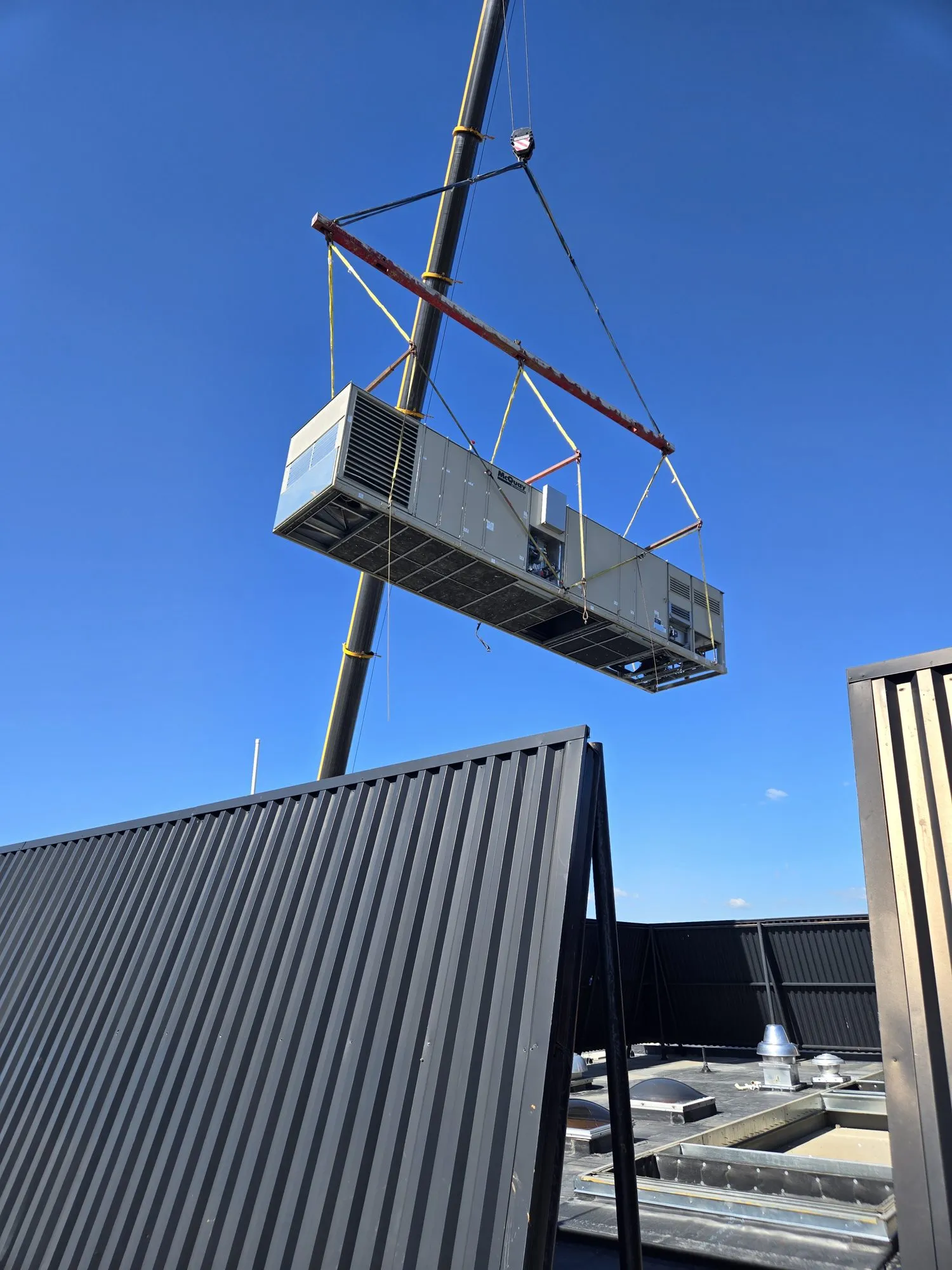 Rooftop air-cooled chiller lifted by crane straight onto a flatbed