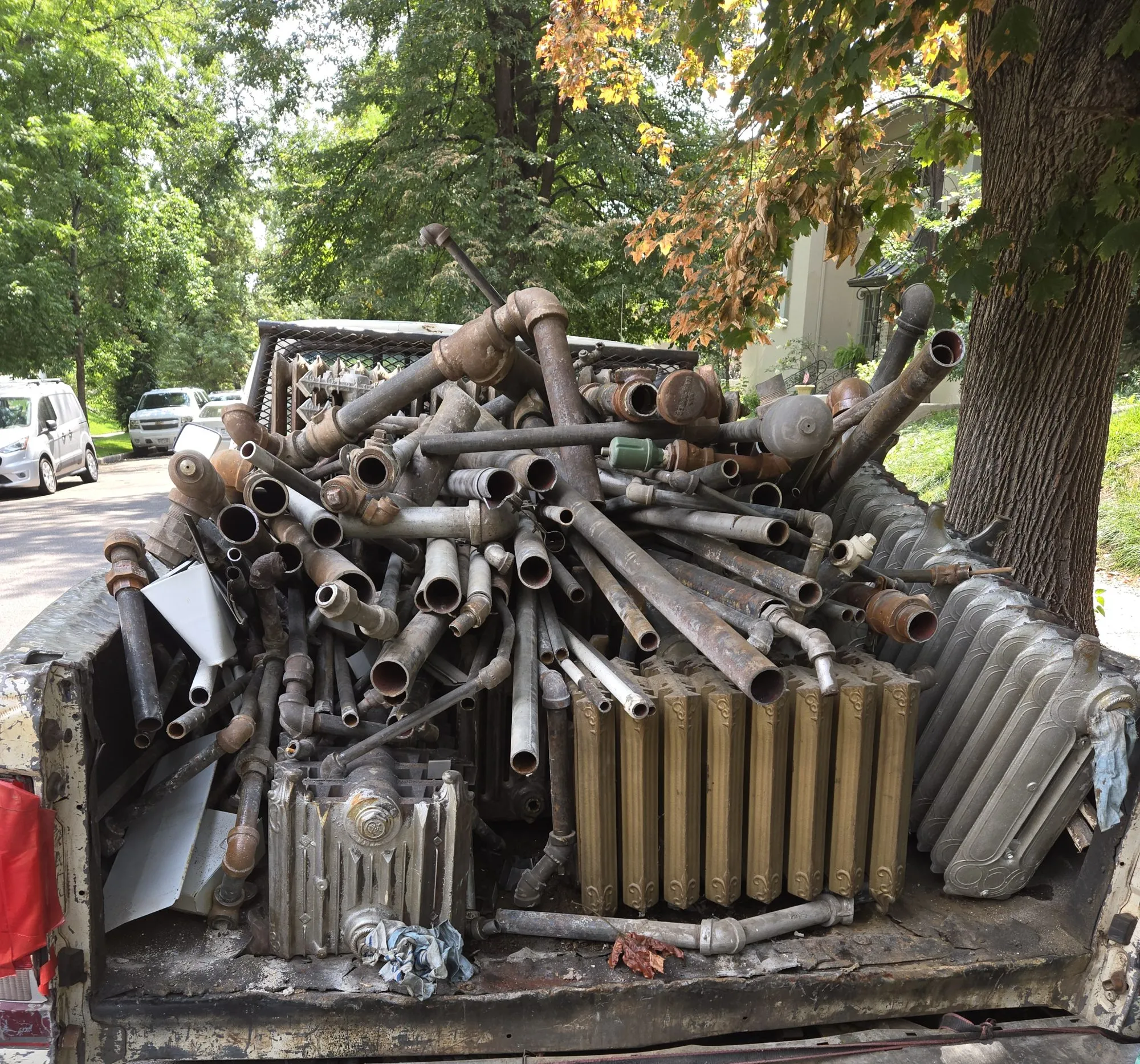 Truck bed loaded with cast iron radiators and pipe for haul-out